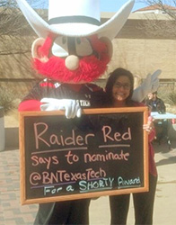 Texas Tech Bookstore Manager Monica Cowie poses with the school's mascot, 'The Masked Rider."