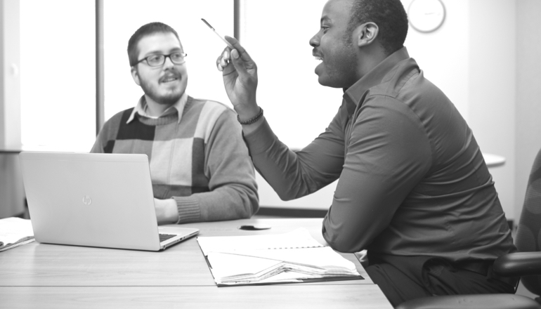 two people working on laptopn and talking